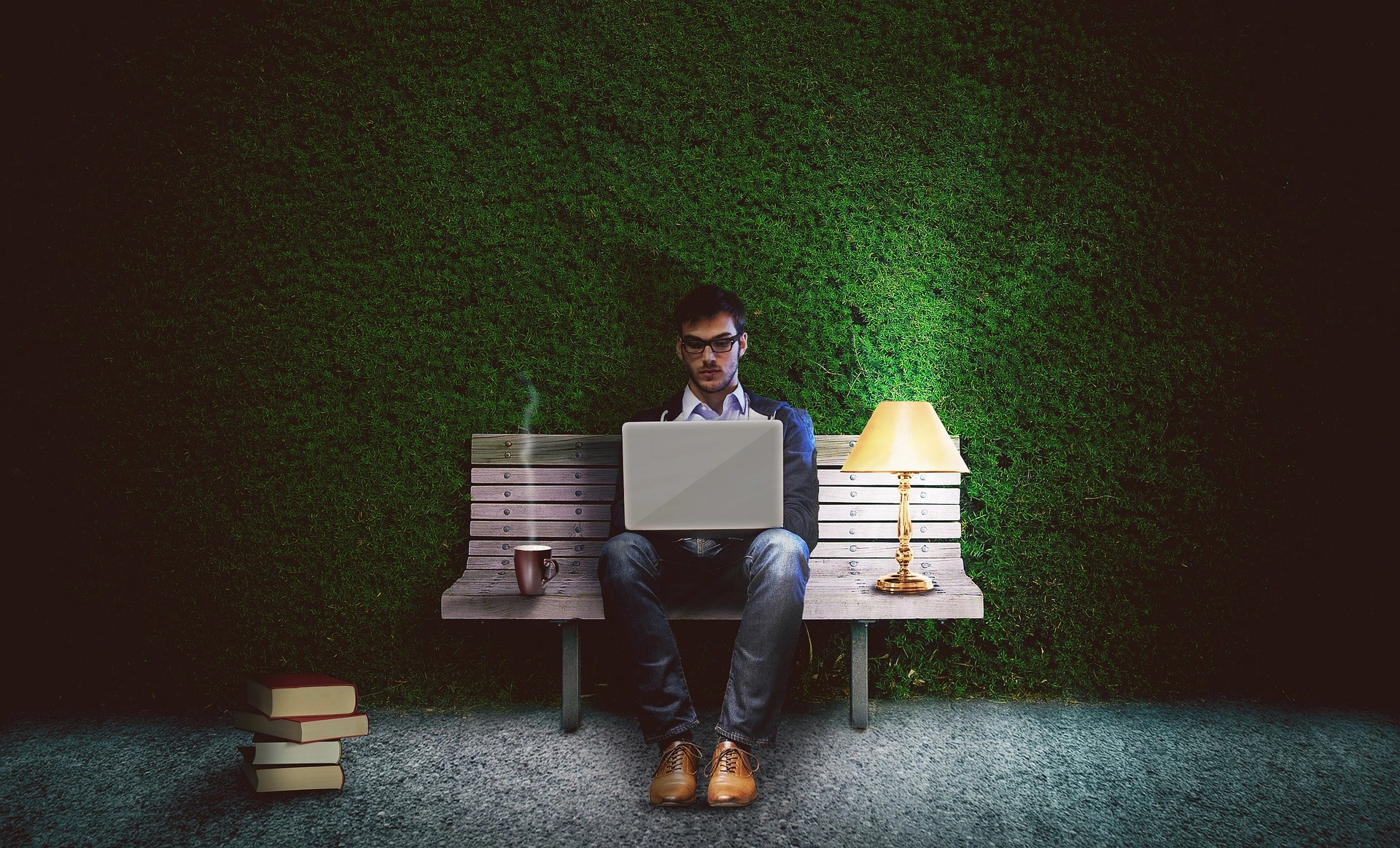 Man working on laptop at park bench